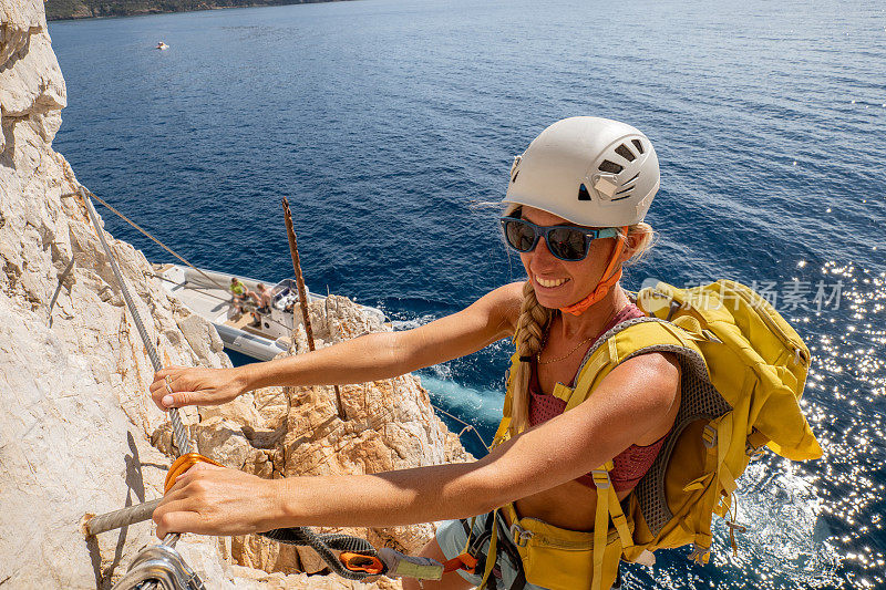 费拉塔岛(Via Ferrata)上的攀登者，年轻的妇女们在攀登海面上的岩石